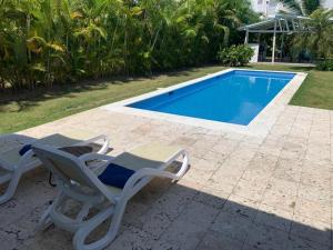 a couple of chairs and a swimming pool at Villa Real Playa Nueva Romana in La Romana