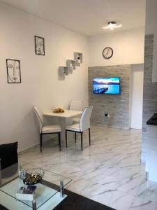 a living room with a table and chairs and a tv at Apartman Miro in Marčana