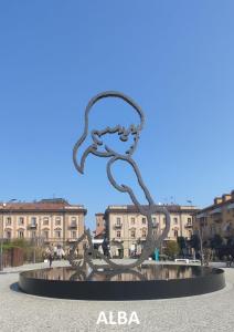 una escultura en una plaza con edificios en el fondo en Al Centro del Borgo, en Guarene