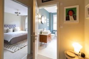a bedroom with a bed and a bathroom with a sink at Exclusive couples retreat with King bed in Scarborough