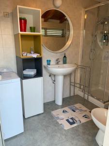 ein Bad mit einem Waschbecken, einer Dusche und einem Spiegel in der Unterkunft Holiday Home Sicily Talia che Bed-du in Punta Braccetto