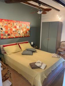 um quarto com uma cama grande e uma ventoinha de tecto em Holiday Home Sicily Talia che Bed-du em Punta Braccetto