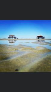 two pavilions in the middle of a body of water at Maison jardin 3 ch centre ville Bassin Arcachon in Audenge