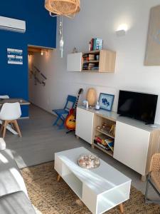 uma sala de estar com uma televisão e uma mesa em Holiday Home Sicily Talia che Bed-du em Punta Braccetto