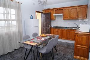 cocina con mesa con sillas y nevera blanca en Lightbooking Luymar con piscina Villa de Mazo, en Mazo