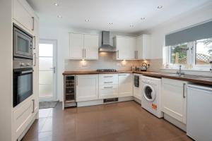 a kitchen with white cabinets and a washer and dryer at Daisy Cottage - Two bed country retreat in Turriff