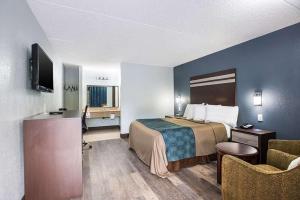 a small hotel room with a bed and a desk at Red Carpet Inn & Suites NJ-73 in Hammonton