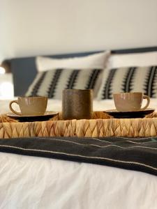 een dienblad met twee koffiekopjes op een bed bij Villa Christina in Ohrid