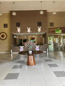 um lobby com uma mesa com flores em Flat E311 - Aldeia das águas em Barra do Piraí