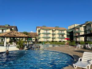 a swimming pool at a hotel with chairs and a building at Flat E311 - Aldeia das águas in Barra do Piraí
