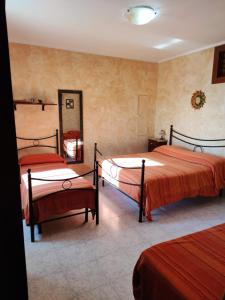 a bedroom with two beds and a mirror at Agriturismo Carrozzino in Sersale