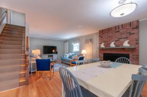 sala de estar con mesa de comedor y chimenea en 29 North Shore Boulevard Extension East Sandwich - - Cape Cod, en East Sandwich