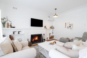 a living room with white furniture and a fireplace at The Seaside Cobbler in Rye