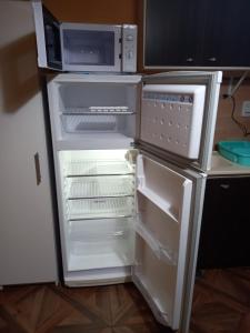 an open refrigerator with a microwave on top of it at Departamento LA LILI in Uspallata