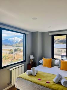 1 dormitorio con 2 camas y ventana grande en Desierto Suites en El Chaltén