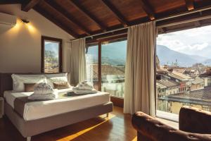 a bedroom with a bed and a large window at Hi room vicolo del vò in Trento