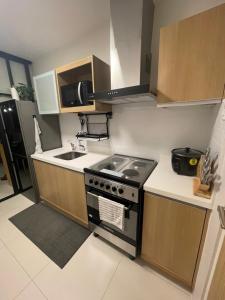 a small kitchen with a stove and a sink at 1BD 1BA PENTHOUSE 2X QUEEN in Nasugbu