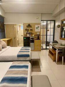 a large room with two beds and a kitchen at 1BD 1BA PENTHOUSE 2X QUEEN in Nasugbu
