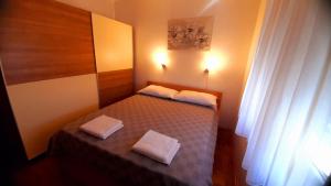 a small bedroom with a bed with two white pillows at Apartman Mediteran - Drage in Drage