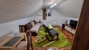 a living room with a couch and a tv at Fortress apartments Niš in Niš