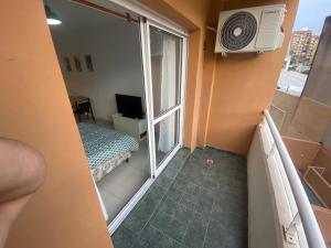 a small room with a balcony with a bed and a window at Depto zona centro muy comodo. in Rosario