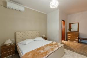 1 dormitorio con cama, tocador y espejo en The Luxe Apartments, en Gjirokastra
