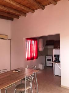 a kitchen with a wooden table and a red window at Los Olivos Apart in San Rafael