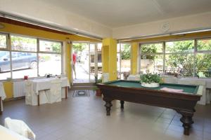 a pool table in a room with tables and windows at Apartments and rooms with parking space Mali Losinj (Losinj) - 2495 in Mali Lošinj