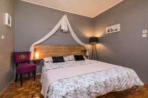 a bedroom with a large bed and a red chair at Apartments and rooms with parking space Mali Losinj (Losinj) - 2495 in Mali Lošinj