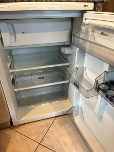 - un réfrigérateur vide avec une porte ouverte dans la cuisine dans l'établissement Le petit bonhomme de neige, à Gérardmer