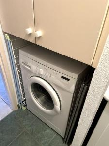eine Waschmaschine und einen Trockner unter einer Theke in einer Küche in der Unterkunft Le petit bonhomme de neige in Gérardmer
