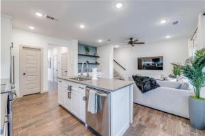 a kitchen and living room with a couch at Stylish townhome near AT&T Stadium, Globe Life, Six Flags & More in Arlington