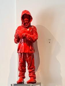 eine rote Statue einer Person in einem Regenmantel in der Unterkunft Design District Wynwood Studio in Miami