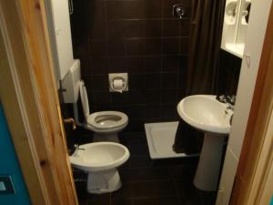 a small bathroom with two toilets and a sink at Panorama Apartment in Claviere