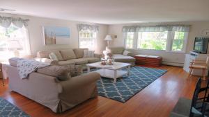 a living room with a couch and a table at 14 Capri Lane Chatham Cape Cod - The Cape House in Chatham