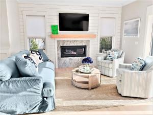 a living room with two chairs and a fireplace at 31 Pine Road West Dennis Cape Cod - - Shark Lookout in West Dennis