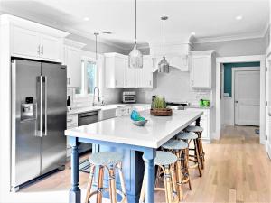 a kitchen with white cabinets and a large island with bar stools at 31 Pine Road West Dennis Cape Cod - - Shark Lookout in West Dennis
