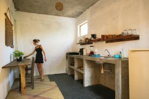 a woman standing in a kitchen with a counter at Casa OM Chakra in Brisas de Zicatela