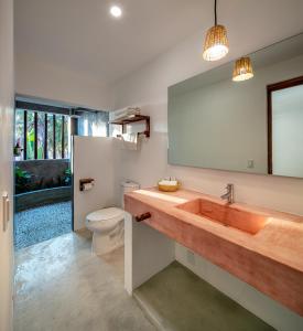 a bathroom with a sink and a toilet and a mirror at Casa Kuaa in Brisas de Zicatela