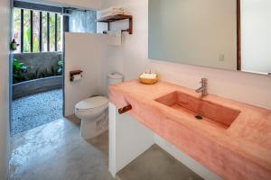 a bathroom with a wooden sink and a toilet at Casa Kuaa in Brisas de Zicatela