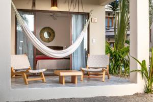 two chairs and a table on the porch of a house at Casa Kuaa in Brisas de Zicatela