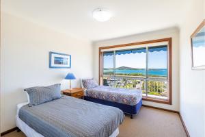a bedroom with a bed and a window with a view at 10 Garuwa Street - Fabulous Fingal Bay water views in Fingal Bay