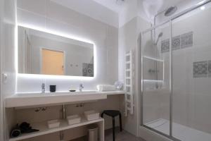 a white bathroom with a sink and a shower at Design Suites Vieux Port in Marseille