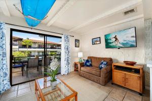 a living room with a couch and a view of the ocean at Casa De Emdeko 222 in Kailua-Kona