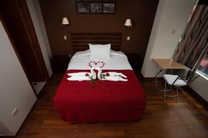a hotel room with a bed with red blanket at Kapac Inn Hotel in Cusco
