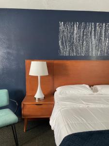 a bedroom with a bed and a lamp and a chair at Starlite Resort in Saugatuck