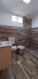 a bathroom with two toilets and a tub and a sink at La casa de las Luces in Villa Carlos Paz