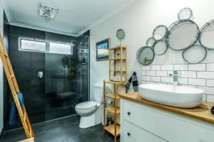 a bathroom with a sink and a shower and a toilet at The Yellow Door Inverloch in Inverloch +8 photos