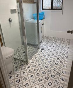 a bathroom with a shower and a toilet with a tile floor at Unit 2, 36 Sunderland Street Evans Head in Evans Head