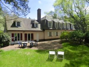 a house with chairs and a table in the yard at Les Argousiers in Le Touquet-Paris-Plage